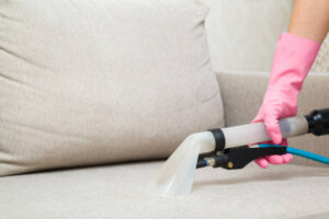 a person vacuums the sofa