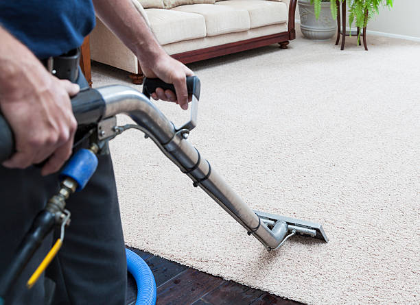 Close-up of a vacuum cleaner head moving over a geometric-patterned carpet, leaving a visibly clean path. This highlights NSH Home Services' attention to detail in carpet cleaning, providing thorough and precise dirt removal for a refreshed look