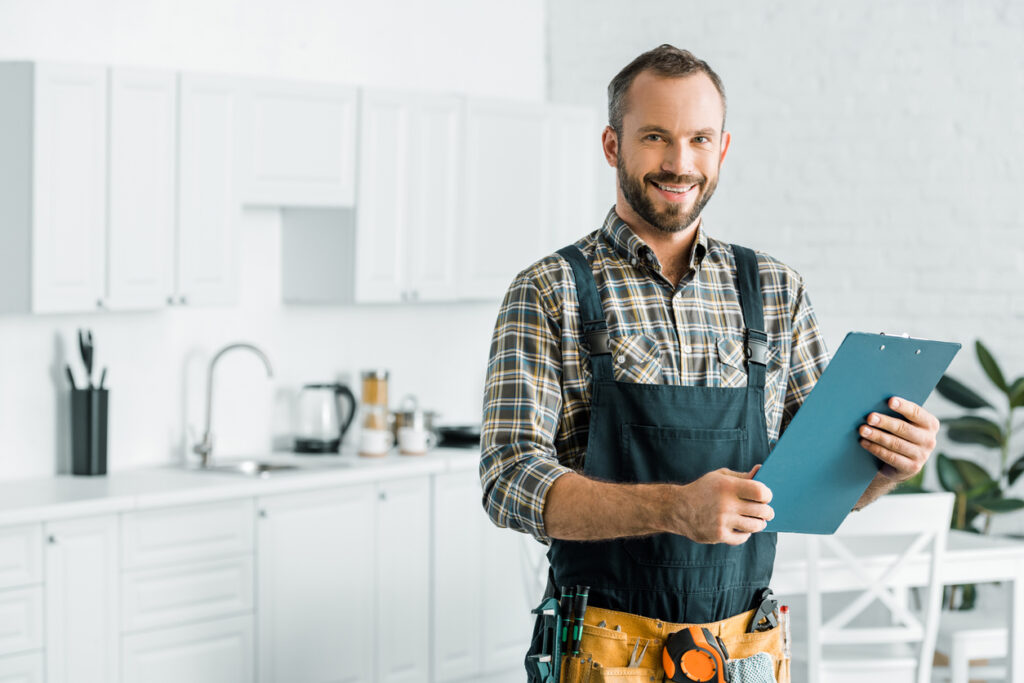 a smiling professional technician is assessing the services that need to be done at a client's home