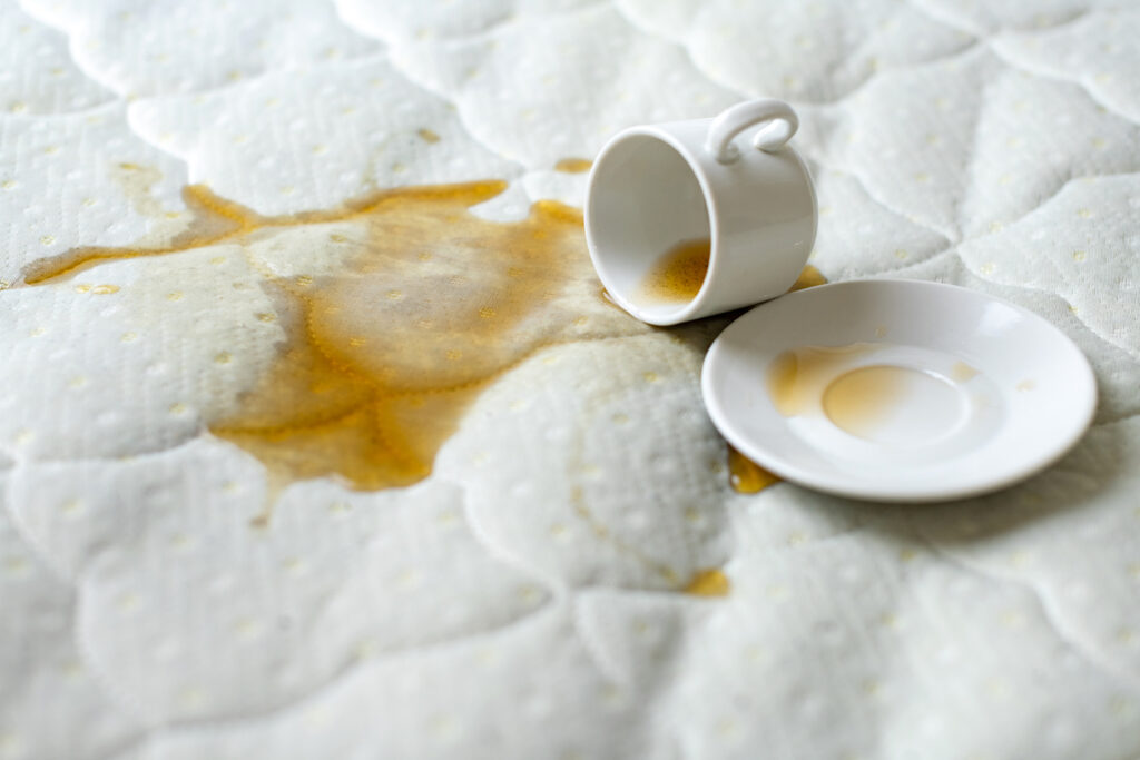 Spilled coffee on a mattress, highlighting the need for professional stain removal and mattress cleaning services offered by NSH Home Services.