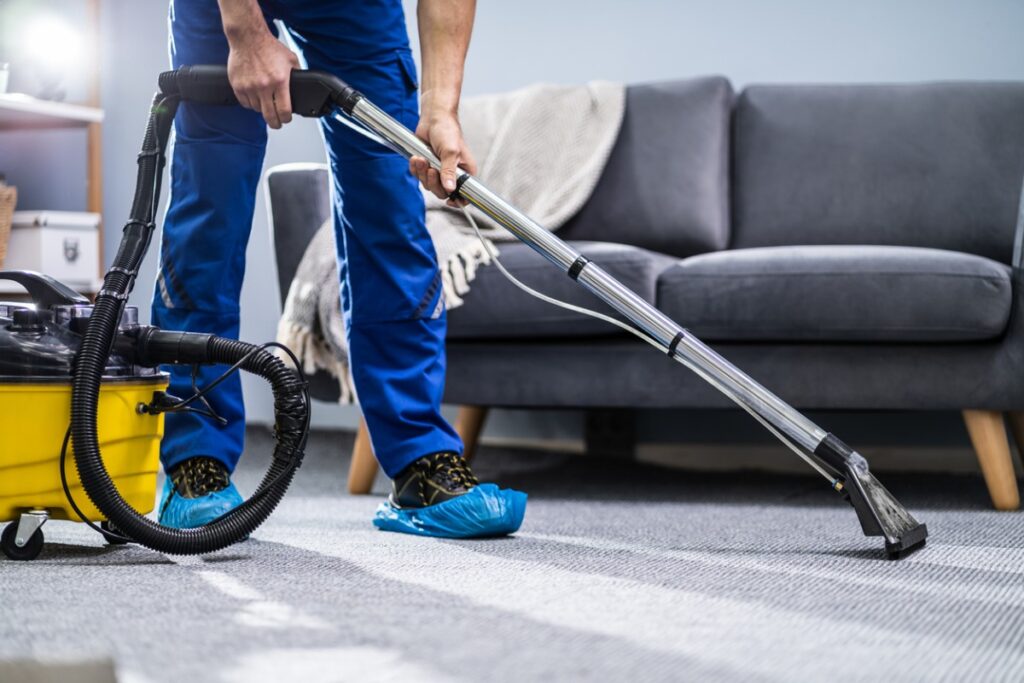 a professional technician is using protection solutions while cleaning the rug